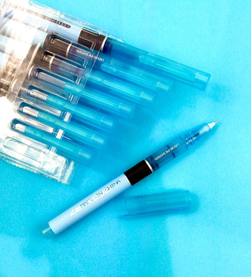 Set of blue pens with clear plastic cases on a blue background