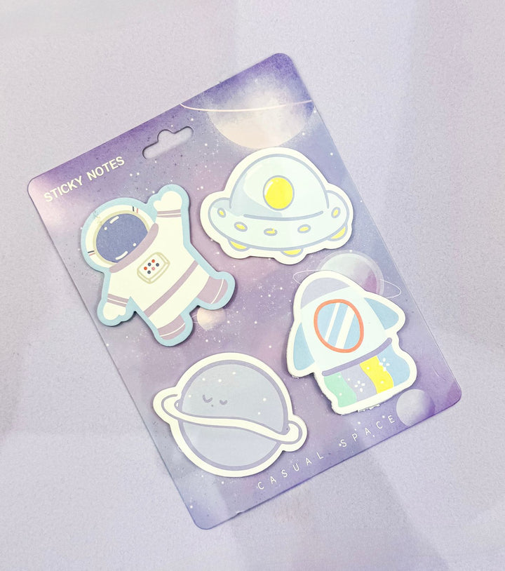 Pack of sticky notes with space-themed designs on a light purple background